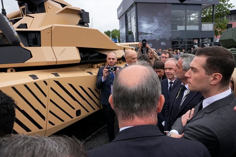 Jordan Bardella, right, president of the far-right National Front party, looks at Leclerc Evolution battle tank at the Eurosatory Defense and Security exhibition, Wednesday, June 19, 2024 in Villepinte, north of Paris. Jordan Bardella, hoping to become France's prime minister, appealed Tuesday to voters to hand his party a clear majority after French President Emmanuel Macron's announcement on June 9 that he was dissolving France's National Assembly, parliament's lower house.( AP Photo/Michel Euler)