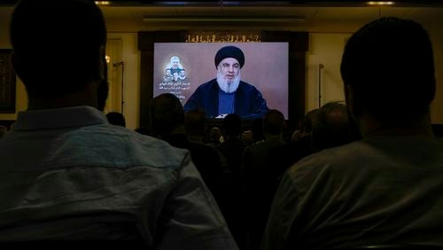 Hezbollah supporters watch a speech given by Hezbollah leader Sayyed Hassan Nasrallah on a screen during a ceremony to commemorate the death of senior Hezbollah commander Taleb Sami Abdullah, 55, who was killed last week by an Israeli strike in south Lebanon, in the southern Beirut suburb of Dahiyeh, Lebanon, Wednesday, June 19, 2024. (AP Photo/Bilal Hussein)
