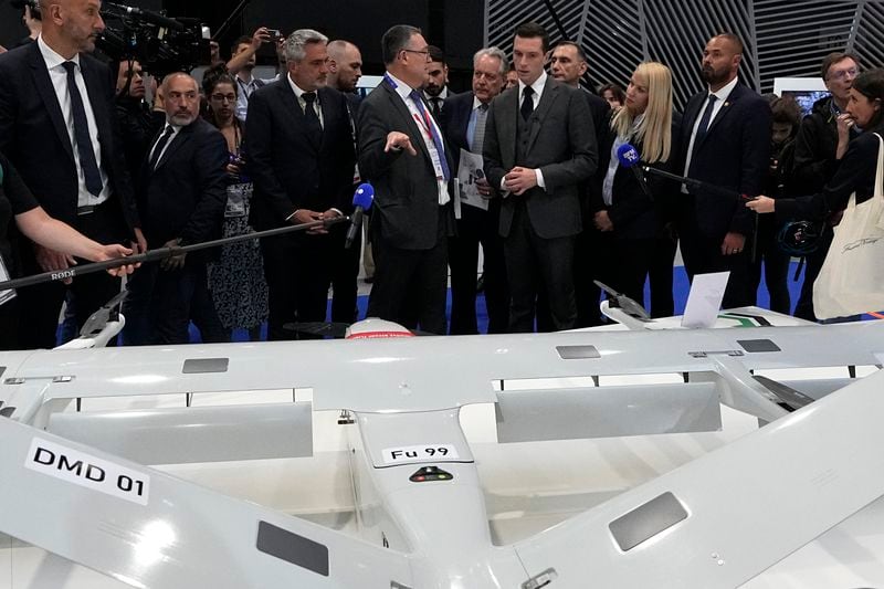 Jordan Bardella, center right, president of the far-right National Front party, looks at a Delair surveillance and intelligence DT4 drone at the Eurosatory Defense and Security exhibition, Wednesday, June 19, 2024 in Villepinte, north of Paris. Jordan Bardella, hoping to become France's prime minister, appealed Tuesday to voters to hand his party a clear majority after French President Emmanuel Macron's announcement on June 9 that he was dissolving France's National Assembly, parliament's lower house.( AP Photo/Michel Euler)