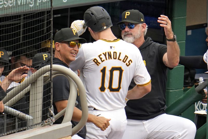 Pittsburgh Pirates' Bryan Reynolds (10) is welcomed on the dugout steps by manager Derek Shelton, right, and hitting coach Andy Haines, left, after hitting a solo home run off Cincinnati Reds relief pitcher Nick Martinez during the eighth inning of a baseball game in Pittsburgh, Wednesday, June 19, 2024. The Pirates won 1-0. (AP Photo/Gene J. Puskar)