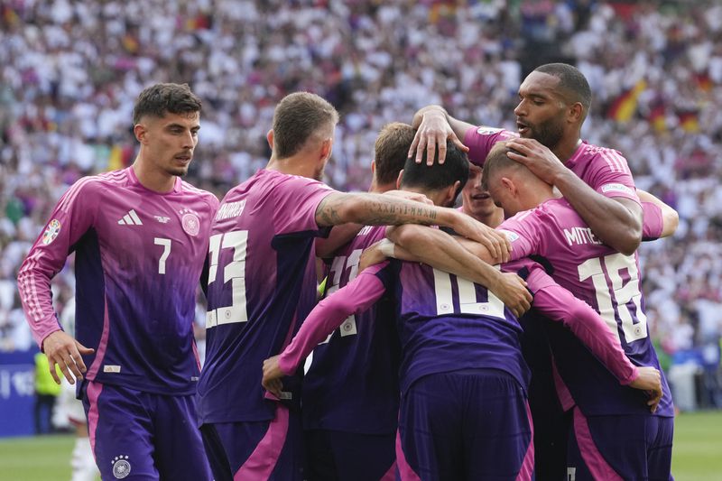 Germany's Jamal Musiala (10) is hugged by teammates after scoring during a Group A match between Germany and Hungary at the Euro 2024 soccer tournament in Stuttgart, Germany, Wednesday, June 19, 2024. (AP Photo/Darko Vojinovic)