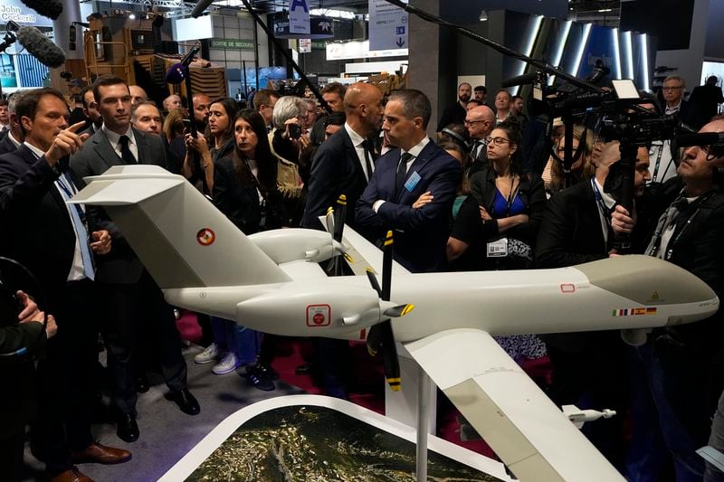 Jordan Bardella, second left, president of the far-right National Front party, looks at replica of an Airbus large long endurance Eurodrone at the Eurosatory Defense and Security exhibition, Wednesday, June 19, 2024 in Villepinte, north of Paris. Jordan Bardella, hoping to become France's prime minister, appealed Tuesday to voters to hand his party a clear majority after French President Emmanuel Macron's announcement on June 9 that he was dissolving France's National Assembly, parliament's lower house.( AP Photo/Michel Euler)