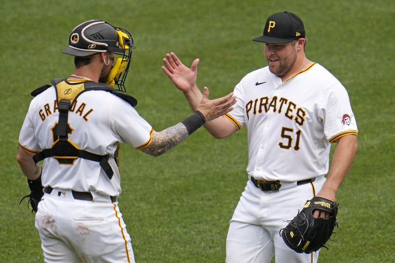 Pittsburgh Pirates relief pitcher David Bednar (51) celebrate with catcher Yasmani Grandal after getting the final out of a baseball game against the Cincinnati Reds in Pittsburgh, Wednesday, June 19, 2024. The Pirates won 1-0. (AP Photo/Gene J. Puskar)