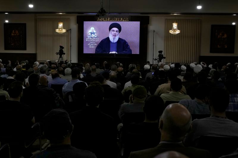 Hezbollah supporters watch a speech given by Hezbollah leader Sayyed Hassan Nasrallah on a screen during a ceremony to commemorate the death of senior Hezbollah commander Taleb Sami Abdullah, 55, who was killed last week by an Israeli strike in south Lebanon, in the southern Beirut suburb of Dahiyeh, Lebanon, Wednesday, June 19, 2024. (AP Photo/Bilal Hussein)
