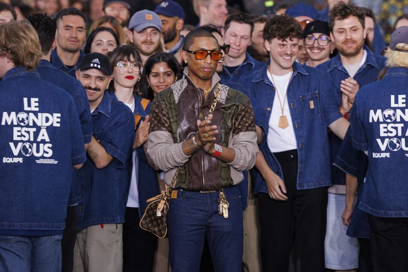 Creative director Pharrell Williams, center, accepts applause following the Louis Vuitton Spring Summer 2025 collection, that was presented in Paris, Tuesday, June 18, 2024. (Photo by Vianney Le Caer/Invision/AP)