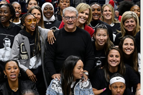 UConn head coach Geno Auriemma poses for a photograph with his players past and present and coaches as he is honored for the most wins in college basketball history, Wednesday, Nov. 20, 2024, in Storrs, Conn. (AP Photo/Jessica Hill)