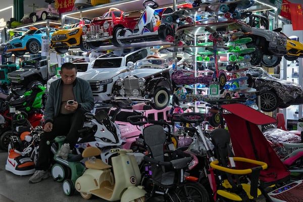 A vendor waits for customers at his store selling electric toy cars at the Yiwu wholesale market in Yiwu, east China's Zhejiang province on Nov. 8, 2024. (AP Photo/Andy Wong)