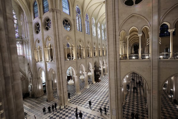 People stroll in Notre-Dame de Paris cathedral while French President Emmanuel Macron visits the restored interiors the monument, Friday, Nov.29, 2024 in Paris. (Christophe Petit Tesson, Pool via AP)