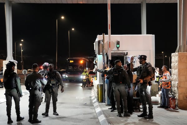 Israeli security forces work at the scene of a shooting attack on a bus near the West Bank town of Beit Jala, early Thursday, Dec. 12, 2024. (AP Photo/Mahmoud Illean)