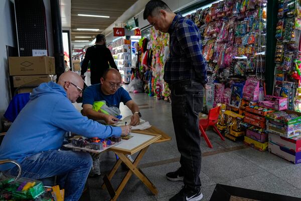 A foreign buyer bargains toys prices with a vendor at the Yiwu wholesale market in Yiwu, east China's Zhejiang province on Nov. 8, 2024. (AP Photo/Andy Wong)