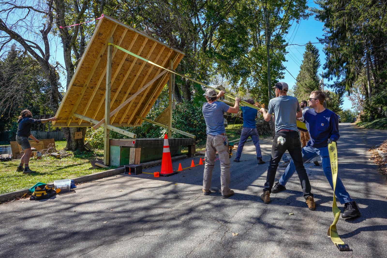 Volunteers work to lower the roof of a platform that will be used to provide water from a community well located on an urban farm that belongs to Bountiful Cities, a nonprofit organization, Monday, Oct. 14, 2024, in Asheville, N.C. (AP Photo/Kathy Kmonicek)