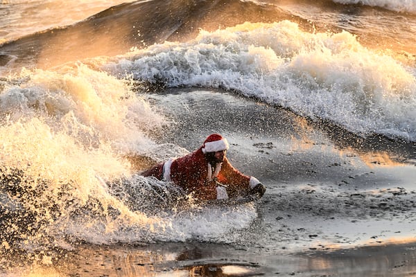 Carlos Hebert Plante, who boogie boards daily, dressed as Santa Claus hits the St-Lawrence River amid an air temperature of -14 degrees Celsius on Christmas Day, in Montreal, Wednesday, Dec. 25, 2024. (Bernard Brault /The Canadian Press via AP)