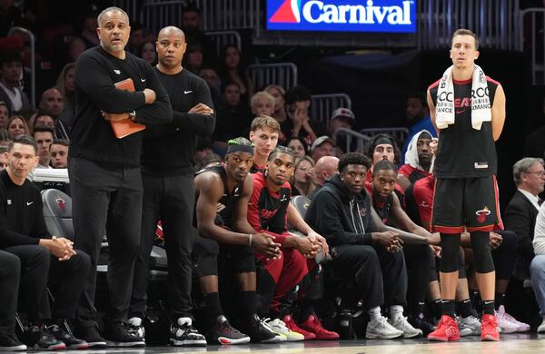 Miami Heat forward Jimmy Butler, third from left, and forward Duncan Robinson, right, watch from the bench during the second half of an NBA basketball game against the Indiana Pacers Thursday, Jan. 2, 2025, in Miami. (AP Photo/Lynne Sladky)