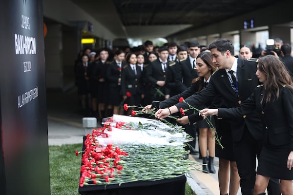 Cadets of the aviation school lay flowers in memory of victims of the Azerbaijan Airlines' Embraer 190 that crashed near the Kazakhstan's airport of Aktau, at the Heydar Aliyev International Airport outside Baku, Azerbaijan, Thursday, Dec. 26, 2024. (AP Photo)