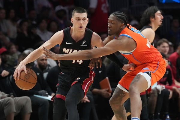 Oklahoma City Thunder forward Jalen Williams (8) defends Miami Heat guard Tyler Herro (14) during the second half of an NBA basketball game, Friday, Dec. 20, 2024, in Miami. (AP Photo/Marta Lavandier)