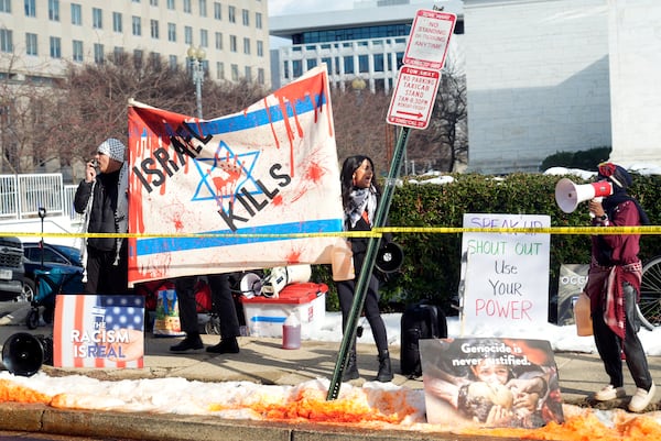 Protesters line the street as President Joe Biden's motorcade passes on its way to the State Department for Biden to speak about foreign policy in Washington, Monday, Jan. 13, 2025. (AP Photo/Susan Walsh)