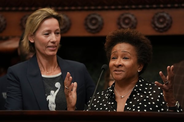 Wanda Sykes, right, accompanied by her wife Alex Sykes, speaks during a news conference in Philadelphia, Monday, Jan. 13, 2025, announcing that the Philadelphia 76ers will partner with Comcast, their current landlord, to build a new arena in South Philadelphia and abandon a deal with the city to build the arena downtown,. (AP Photo/Matt Rourke)