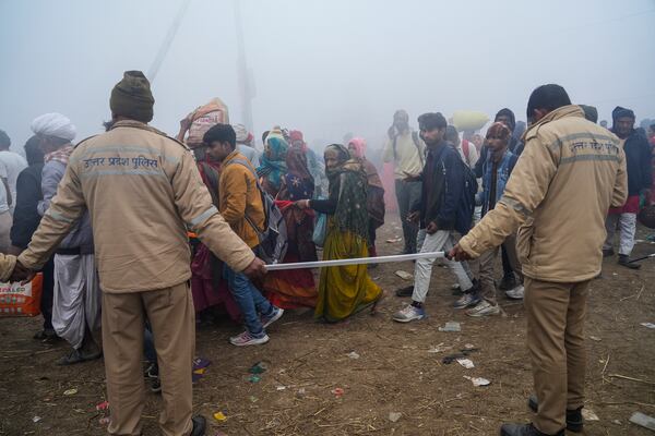 Policemen manage the crowd, a day after a stampede killed Hindu devotees who had gathered to take a holy dip at the Sangam, the confluence of the Ganges, the Yamuna and the mythical Saraswati rivers, during the Maha Kumbh festival in Prayagraj, India, Thursday, Jan. 30, 2025. (AP Photo/Deepak Sharma)