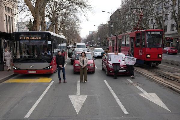 People stopping traffic, stand in silence during ongoing protests that erupted after a concrete canopy fell in the November and killed 15 people in Belgrade, Serbia, Wednesday, Jan. 29, 2025. (AP Photo/Darko Vojinovic)