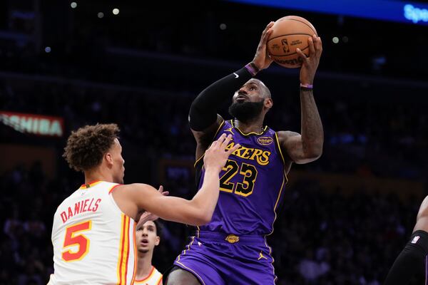 Los Angeles Lakers forward LeBron James, right, shoots as Atlanta Hawks guard Dyson Daniels defends during the first half of an NBA basketball game, Friday, Jan. 3, 2025, in Los Angeles. (AP Photo/Mark J. Terrill)