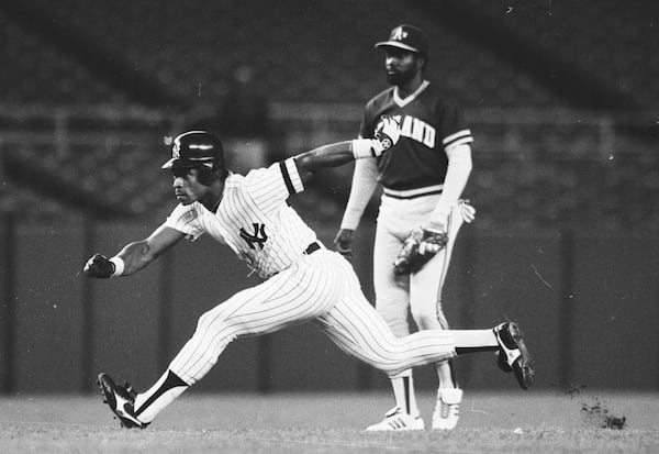 FILE - New York Yankees' Rickey Henderson, left, takes off to steal third base during a baseball game against the Oakland Athletics at Yankee Stadium in New York, May 21, 1986. (AP Photo/Ray Stubblebine, File)