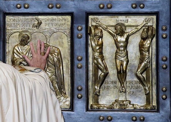 FILE - Pope Francis pushes open the Holy Door of St. Peter's Basilica, formally launching the Holy Year of Mercy, at the Vatican, Tuesday, Dec. 8, 2015. (AP Photo/Gregorio Borgia, File)