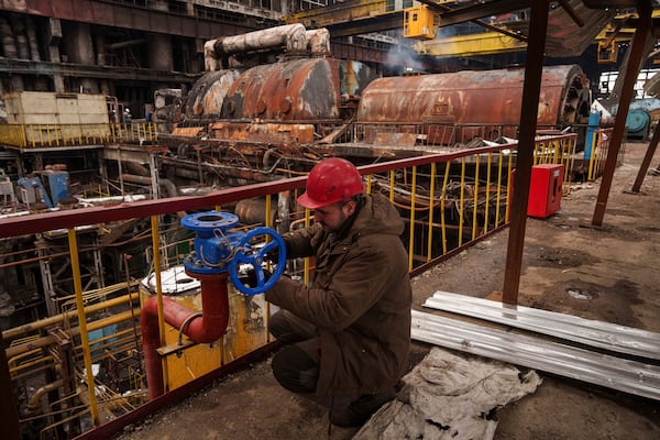 A worker repairs equipment at DTEK's power plant after a recent Russian missile attack in Ukraine, Nov. 28, 2024. (AP Photo/Evgeniy Maloletka)