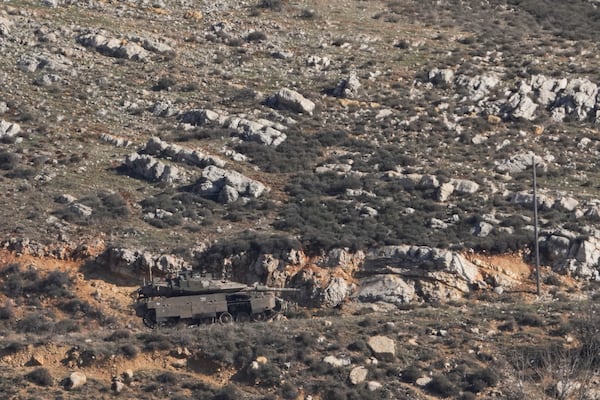 An Israeli tank maneuvers on the buffer zone near the so-called Alpha Line that separates the Israeli-controlled Golan Heights from Syria, viewed from the town of Majdal Shams, Friday, Dec. 20, 2024. (AP Photo/Matias Delacroix)