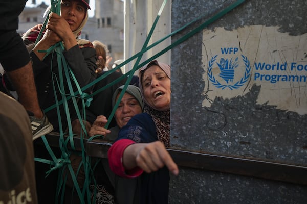 Women line up in front of a bakery to get their share of bread in Deir al-Balah, Gaza Strip, Thursday Nov. 21, 2024. Some bakeries in the Gaza Strip have reopened Thursday morning after shuttering for several days due to a flour shortage and lack of food aid.(AP Photo/Abdel Kareem Hana)