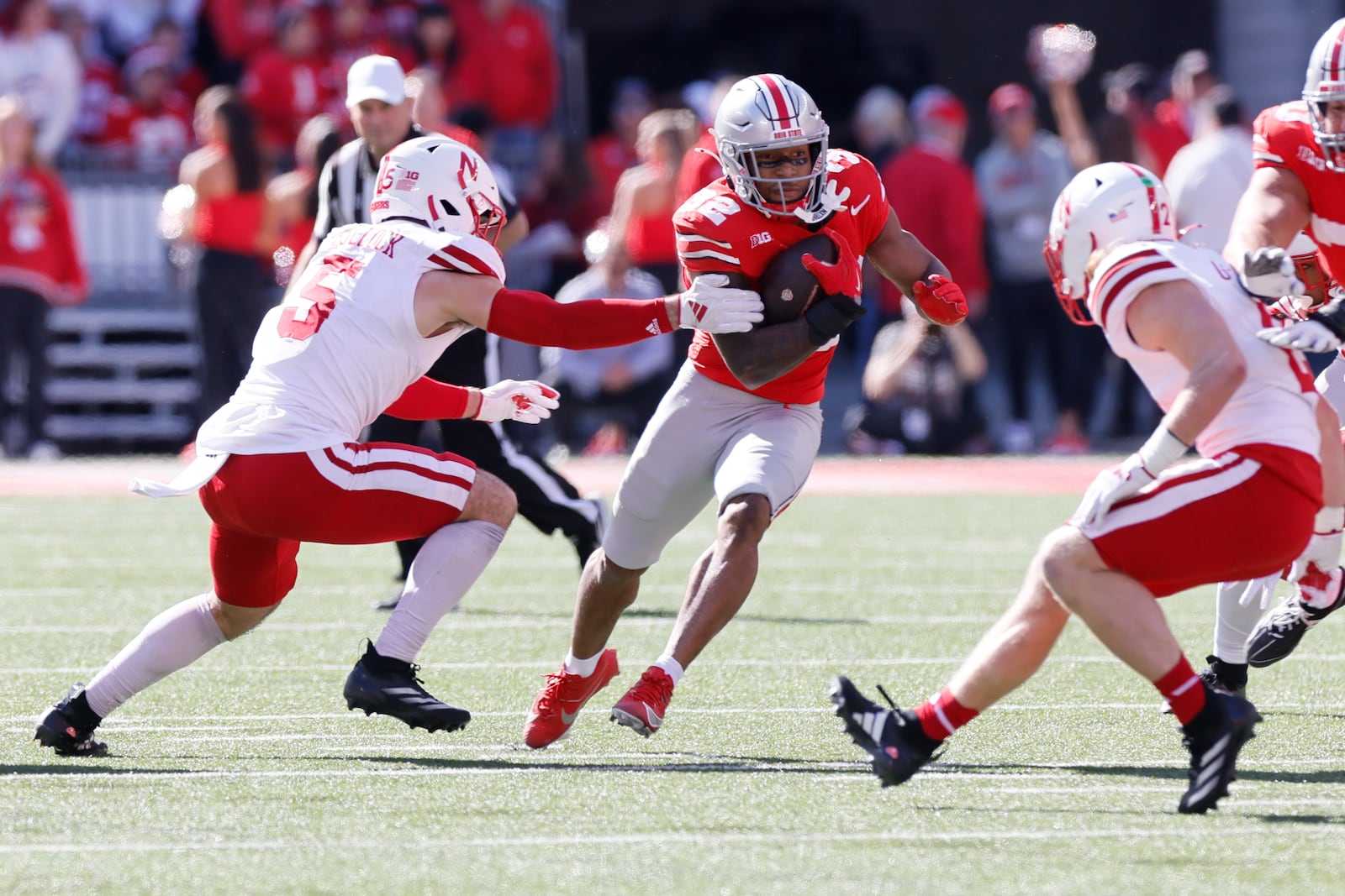 Ohio State running back TreVeyon Henderson, center, cuts up field between Nebraska linebacker John Bullock, left, and defensive back Isaac Gifford during the first half of an NCAA college football game Saturday, Oct. 26, 2024, in Columbus, Ohio. (AP Photo/Jay LaPrete)