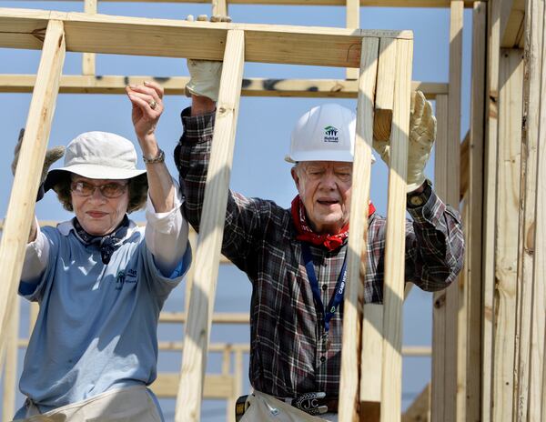 FILE - Former President Jimmy Carter, right, and former first lady Rosalynn Carter raise a wall as they help build a Habitat for Humanity house in Violet, La., May 21, 2007. The pair were working on the 1,000th Habitat for Humanity house in the Gulf Coast region since hurricane Katrina and Rita. (AP Photo/Alex Brandon, File)