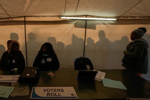 Electoral workers prepare to open the voting station as voters line up to cast their ballot for general elections in Alexandra, near Johannesburg, South Africa, Wednesday, May 29, 2024. (AP Photo/Themba Hadebe)