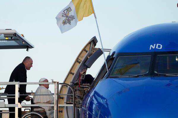 Pope Francis boards an airplane at Rome's Fiumicino, airport as he leaves for his one-day visit to Ajaccio in he French island of Corsica, Sunday, Dec.15, 2024. (AP Photo/Gregorio Borgia)