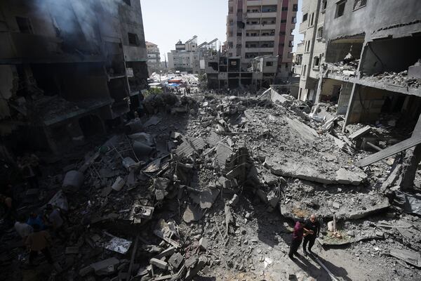 FILE - Palestinians look at the aftermath of an Israeli bombing in Nuseirat refugee camp, Gaza Strip, June 8, 2024. (AP Photo/Jehad Alshrafi, File)