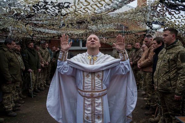 Military chaplain Yurii of 24th Mechanized Brigade holds a church service for infantry unit during Christmas near the frontline town of Chasiv Yar, Donetsk region, Ukraine, Wednesday Dec. 25, 2024. (AP Photo/Evgeniy Maloletka)