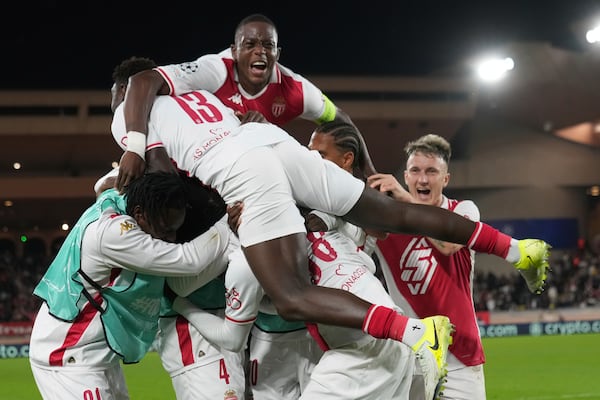 Monaco's players celebrate after their teammate Soungoutou Magassa scoring his side's 2nd goal against Benfica during a Champions League opening phase soccer match at the Louis II stadium in Monaco, Wednesday, Nov. 27, 2024. (AP Photo/Laurent Cipriani)