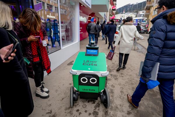 An autonomous food delivery vehicle serves people during the Annual Meeting of World Economic Forum in Davos, Switzerland, Wednesday, Jan. 22, 2025. (AP Photo/Markus Schreiber)