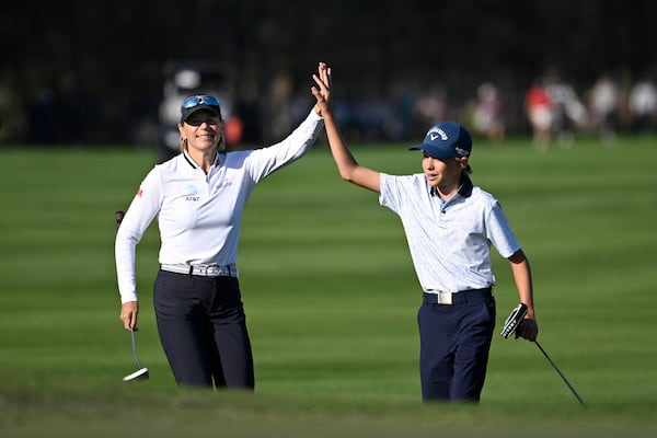 Annika Sorenstam, left, congratulates her son Will McGee after his shot to the 18th green during the first round o the PNC Championship golf tournament, Saturday, Dec. 21, 2024 in Orlando, Fla. (AP Photo/Phelan M. Ebenhack)