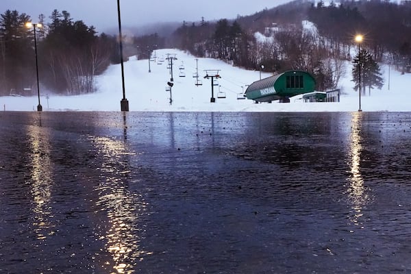 Rain water from a winter storm flows through the empty parking lot near the Panorama lift at the Gunstock Mountain Resort ski area , Wednesday, Dec. 11, 2024, in Gilford, N.H. (AP Photo/Charles Krupa)