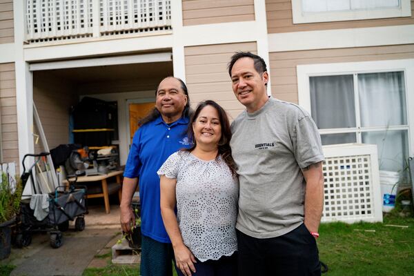 From left to right, Ron Sambrano, Tamara, and Kawehi Akiona pose for a portrait at their home, Thursday, Dec. 12, 2024, in Wailuku, Hawaii. Sambrano and the Akionas are part of the 253 households receiving funds from the Council for Native Hawaiian Advancement. (AP Photo/Mengshin Lin)