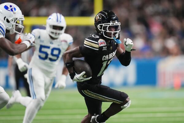 Colorado wide receiver Travis Hunter (12) runs for a touchdown against BYU after making a catch during the second half of the Alamo Bowl NCAA college football game, Saturday, Dec. 28, 2024, in San Antonio. (AP Photo/Eric Gay)