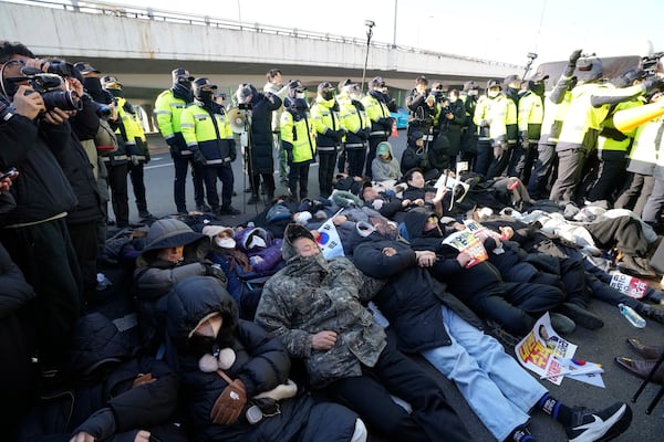 Supporters of impeached South Korean President Yoon Suk Yeol lie down on the ground as Yoon faces potential arrest after a court on Tuesday approved a warrant for his arrest, near the presidential residence in Seoul, South Korea, Thursday, Jan. 2, 2025. (AP Photo/Ahn Young-joon)