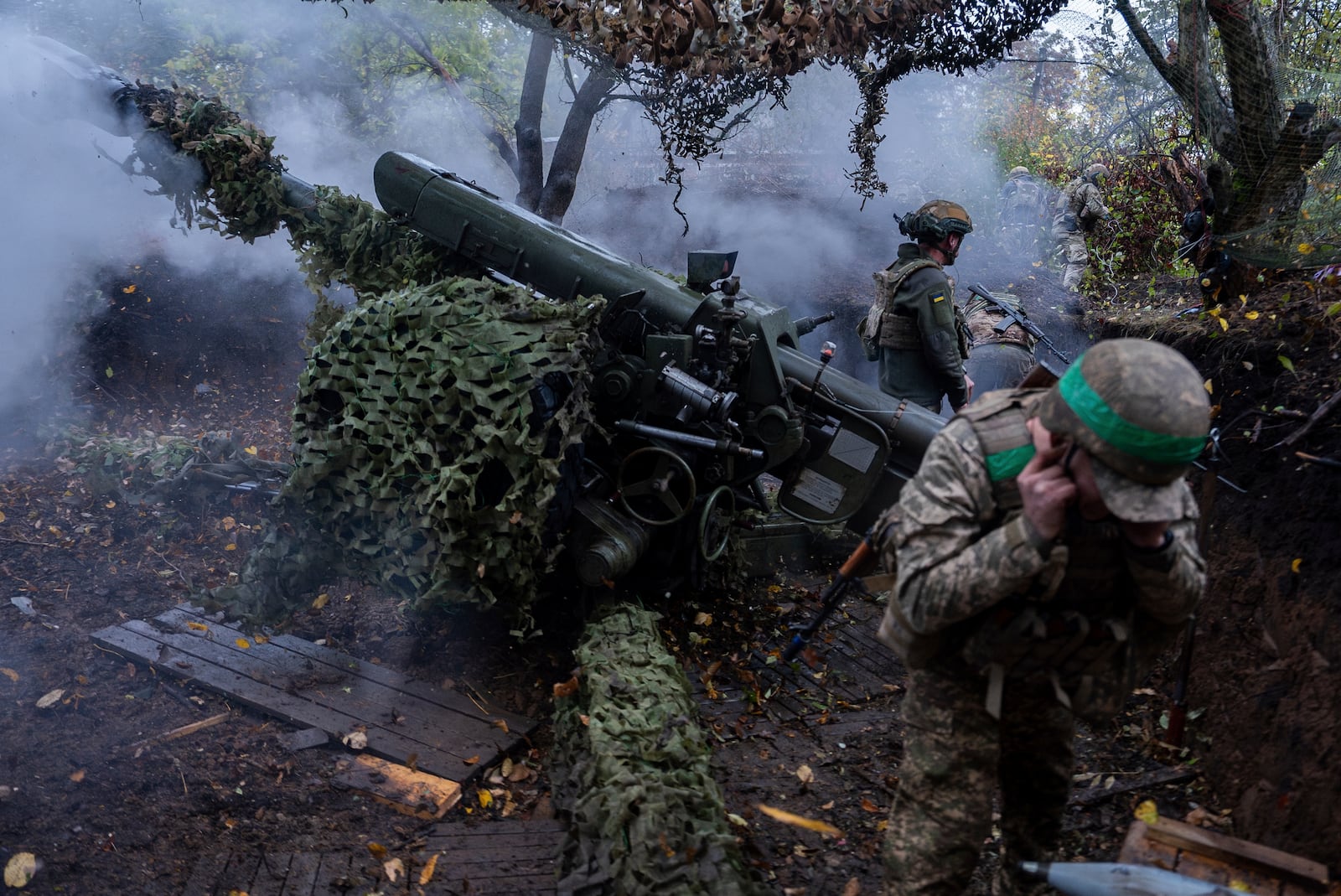 Ukrainian servicemen of Khartia brigade fire D-30 Howitzer towards Russian positions in Kharkiv region, Ukraine, Wednesday, Oct. 16, 2024. (AP Photo/Alex Babenko)