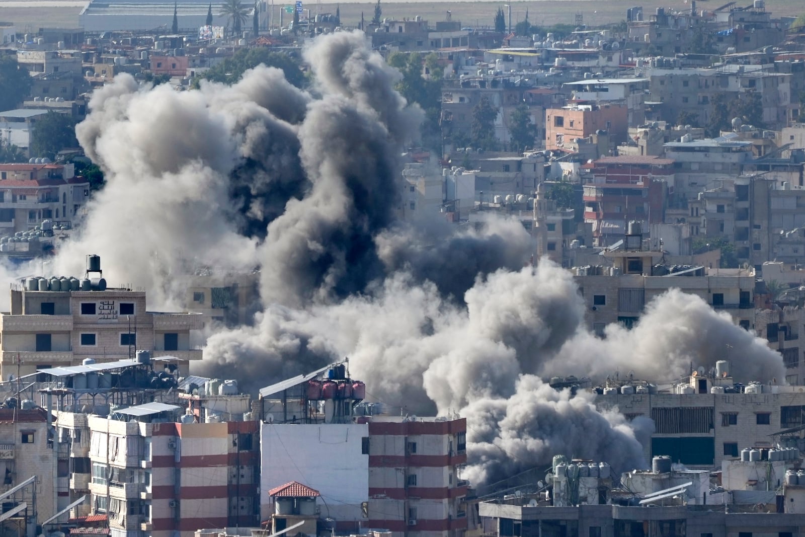 Smoke rises between buildings hit in an Israeli airstrike in Dahiyeh, in the southern suburb of Beirut, Lebanon, Thursday, Nov. 14, 2024. (AP Photo/Hussein Malla)