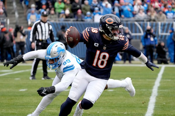 Chicago Bears quarterback Caleb Williams escapes the pressure of Detroit Lions defensive end Za'Darius Smith during the first half of an NFL football game Sunday, Dec. 22, 2024, in Chicago. (AP Photo/Nam Y. Huh)