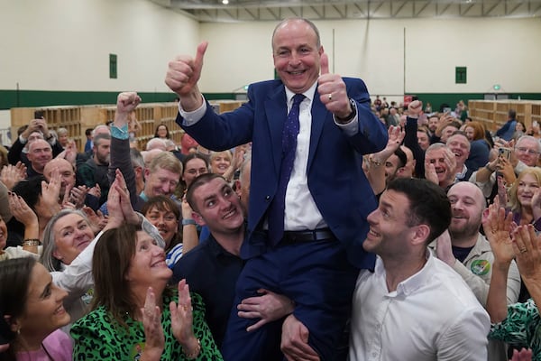 Fianna Fail leader Micheal Martin is hoisted up by his sons Cillian and Micheal Aodh, after he was deemed elected in the Cork South Central constituency at the election count centre at Nemo Rangers GAA Club in Cork, after the General Election, Saturday, Nov. 30, 2024. (Jacob King/PA via AP)