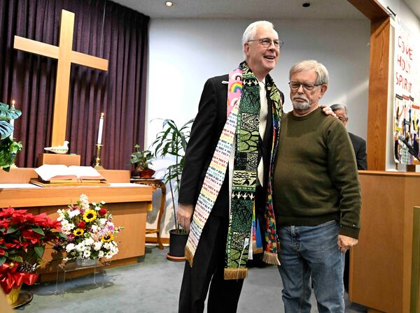 Altadena Community Church parishioner Tim Gregory, right, shows his emotions after placing a stole around the neck of Pastor Paul Tellstrom after after all the stoles were burned along with the church from the Eaton Fire, during church services at Montebello Plymouth Congregational Church in Montebello, Calif., Sunday, Jan. 12, 2025. (Will Lester/The Orange County Register via AP)