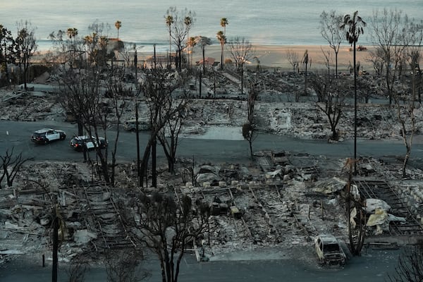 Los Angeles Police guard burned homes at the Pacific Palisades Bowl Mobile Estates destroyed by the Palisades Fire are seen in the Pacific Palisades neighborhood of Los Angeles, Thursday, Jan. 16, 2025. (AP Photo/Damian Dovarganes)