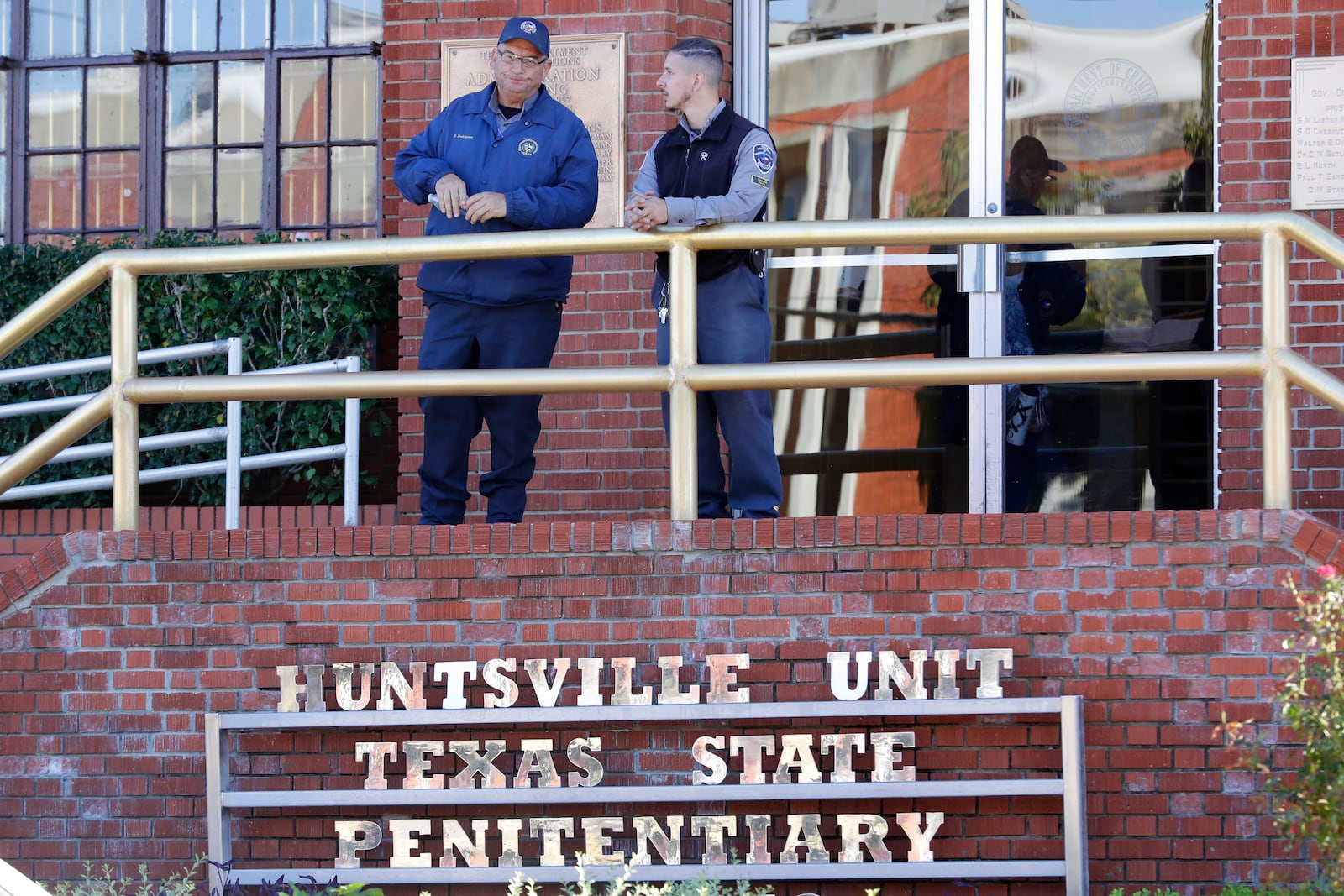 Prison staff gather at the main entrance of the building housing the execution chamber as Robert Roberson awaits his execution, at the Huntsville Unit of the Texas State Penitentiary, Thursday, Oct. 17, 2024, in Huntsville, Texas. (AP Photo/Michael Wyke)