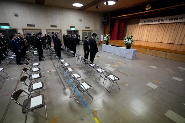 Guests offer a moment of silence during a memorial ceremony for the Sado Island Gold Mine in Sado, Niigata prefecture, Japan, Sunday, Nov. 24, 2024. (AP Photo/Eugene Hoshiko)